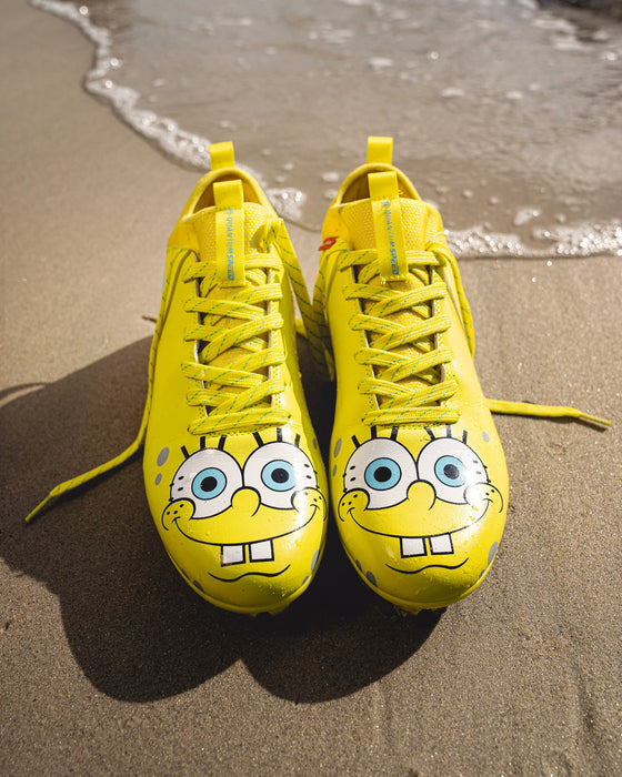 Phenom Elite SpongeBob cleat lifestyle photo — athlete wearing yellow cleats on field