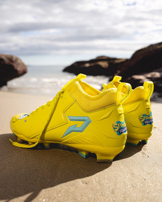 Phenom Elite SpongeBob cleat lifestyle photo — athlete posing with cleats