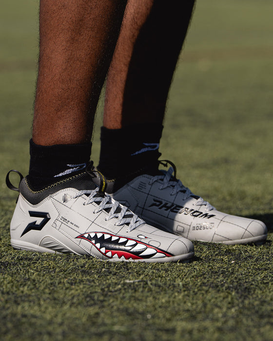 Phenom Elite Warhawk cleat lifestyle photo — athlete wearing grey low-cut speed cleats