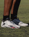Phenom Elite Warhawk cleat lifestyle photo — athlete wearing grey low-cut speed cleats