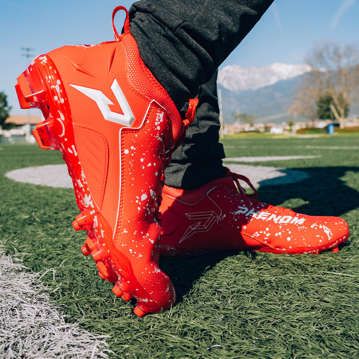 Phenom Elite Kool-Aid Cherry cleat lifestyle photo — cleats with packet