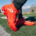 Phenom Elite Kool-Aid Cherry cleat lifestyle photo — cleats with packet